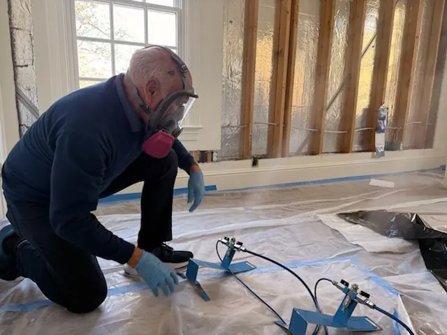 A restoration technician setting drying equipment in a Winston-Salem home stripped to the studs